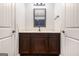 Bathroom with white wall and marble sink, and chocolate color drawers between two white doors at 224 Jester Ct, Mcdonough, GA 30252