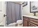 Bathroom featuring a shower with gray curtain, a white toilet, and a sink with storage underneath at 224 Jester Ct, Mcdonough, GA 30252