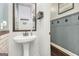 Cozy powder room with pedestal sink, decorative mirror, and subtle wall paneling at 224 Jester Ct, Mcdonough, GA 30252