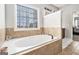 This bathroom features a white soaking tub with tile surround and large windows at 224 Jester Ct, Mcdonough, GA 30252