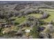 Aerial view of a property with a green roofed house surrounded by trees and fields at 128 Turner Ln, Bowdon, GA 30108