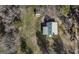 Aerial view of a property with a green roofed house and a shed surrounded by trees at 128 Turner Ln, Bowdon, GA 30108