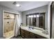 Bright bathroom featuring a tiled walk-in shower, a light vanity with drawers, and neutral walls at 128 Turner Ln, Bowdon, GA 30108