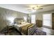Bedroom with wood accent wall, ceiling fan, wood floors, and a comfortable black metal bed frame at 128 Turner Ln, Bowdon, GA 30108