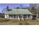 Classic house with a brick chimney and inviting front porch with white railings at 128 Turner Ln, Bowdon, GA 30108