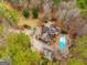 Stunning aerial view of the property, showcasing the home, pool, lush landscaping, and surrounding mature trees at 233 Spear Rd, Fayetteville, GA 30215