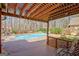 Inviting backyard featuring a pool, hot tub, lush greenery, and a covered deck for outdoor relaxation and enjoyment at 233 Spear Rd, Fayetteville, GA 30215
