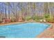 A refreshing pool with a waterfall feature, hot tub and wooden swing set in a serene backyard setting at 233 Spear Rd, Fayetteville, GA 30215