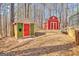 Colorful backyard sheds with mature trees in the background, adding character and storage to the outdoor space at 233 Spear Rd, Fayetteville, GA 30215