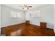 Bright bedroom showcasing hardwood floors, two windows, and traditional wooden nightstands at 623 Swan Lake Rd, Stockbridge, GA 30281