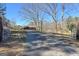 Long driveway leading to a charming brick house surrounded by bare trees and greenery at 623 Swan Lake Rd, Stockbridge, GA 30281