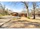 Single-story brick home featuring a covered carport and a long driveway, nestled amongst mature trees at 623 Swan Lake Rd, Stockbridge, GA 30281