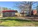 Outdoor scenery featuring sheds and a charming brick house amidst bare trees and green grass at 623 Swan Lake Rd, Stockbridge, GA 30281