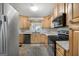 Well-lit kitchen featuring stainless steel appliances, wood cabinetry, and a functional layout at 623 Swan Lake Rd, Stockbridge, GA 30281