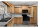 Efficient kitchen with wood cabinets, white countertops, and modern black appliances at 623 Swan Lake Rd, Stockbridge, GA 30281