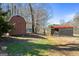 Rustic sheds and structures in a rural setting, with a gate and mature trees at 623 Swan Lake Rd, Stockbridge, GA 30281