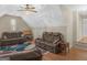 Spacious bonus room with vaulted ceiling, ceiling fan, brown leather sofas, and colorful patterned rug at 355 Parker Rd, Covington, GA 30014