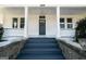 Front porch with pillars and stone steps leading to the front door at 1669 Spring Ne St, Conyers, GA 30012