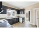 Bright kitchen with black cabinets, stainless steel appliances, and tile backsplash at 1669 Spring Ne St, Conyers, GA 30012