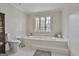 Elegant bathroom with a tiled bathtub, window view, toilet, and vanity at 375 Darren Dr, Fayetteville, GA 30215