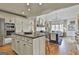 Bright kitchen featuring an island, white cabinetry, stainless steel appliances, and seamless flow into the living room at 375 Darren Dr, Fayetteville, GA 30215