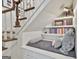 Reading nook under staircase with custom shelving, pillows, and books at 375 Darren Dr, Fayetteville, GA 30215