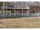 Backyard view featuring the raised deck on a brick home and a white picket fence at 2545 Rockbridge Nw Rd, Conyers, GA 30012