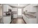 Well-lit kitchen with white cabinets, granite countertops, and modern appliances at 505 Phillips Dr, Palmetto, GA 30268