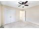 Carpeted bedroom with double closet, open doorway, and a ceiling fan at 603 Honey Creek Rd, Mcdonough, GA 30252