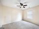 A bright bedroom with carpeted floors, a ceiling fan, and a window for natural light at 603 Honey Creek Rd, Mcdonough, GA 30252