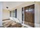 View of front door and covered porch with wooden door and decorative sidelight at 603 Honey Creek Rd, Mcdonough, GA 30252