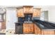 Well-lit kitchen with wooden cabinets, black countertops, and modern appliances at 603 Honey Creek Rd, Mcdonough, GA 30252
