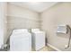 Functional laundry room with washer, dryer, and built-in storage shelves at 603 Honey Creek Rd, Mcdonough, GA 30252