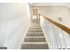 Carpeted staircase featuring a wood railing and white spindles at 603 Honey Creek Rd, Mcdonough, GA 30252