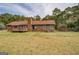 Exterior back view featuring wood siding, a deck, mature trees, and a well-maintained lawn at 5687 Highway 212 N, Covington, GA 30016