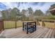 Outdoor wooden deck featuring wooden railings and a high-top table with wooden stools at 5687 Highway 212 N, Covington, GA 30016