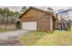 Spacious two-car garage featuring wood siding, a paved driveway, and a well-maintained lawn at 5687 Highway 212 N, Covington, GA 30016