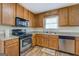 Cozy kitchen with wooden cabinets, stainless steel appliances, and a window over the sink at 5687 Highway 212 N, Covington, GA 30016