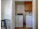 Bright laundry room featuring a modern washer and dryer with overhead cabinet storage at 5687 Highway 212 N, Covington, GA 30016