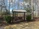 Backyard swing surrounded by bare trees and evergreen shrubs; a quiet place to relax at 650 Harris Dr, Locust Grove, GA 30248