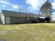 Back of home showing screened in patio, set on a large, verdant lawn at 650 Harris Dr, Locust Grove, GA 30248