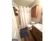 Full bathroom with shower, cabinet, wood-look floors and vanity lighting at 650 Harris Dr, Locust Grove, GA 30248