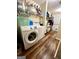 Bright laundry room with washer, dryer, shelving and wood-look floors at 650 Harris Dr, Locust Grove, GA 30248