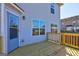 Back deck with wood railing, entry door, and two windows on the rear of the home at 205 Siesta Key Ct, Locust Grove, GA 30248