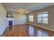 Open-concept living room featuring laminate flooring, a fireplace, a ceiling fan, and natural light at 205 Siesta Key Ct, Locust Grove, GA 30248