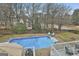 Aerial view of a home with a backyard pool, patio and lush greenery in a residential neighborhood at 100 Spincast Ct, Peachtree City, GA 30269