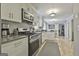 Open kitchen showcasing stainless steel appliances, white cabinets, and connection to a dining area at 100 Spincast Ct, Peachtree City, GA 30269