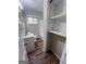 Hallway leading to the bathroom featuring laminate floors and a closet with built-in shelving at 3401 Longleaf Dr, Decatur, GA 30032