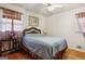 This bedroom features hardwood floors, two windows, and simple decor, with a woven headboard at 1387 John Robert Dr, Morrow, GA 30260