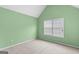 Cozy bedroom with a neutral carpet, bright green walls, and natural light from the window at 704 Davenport Ct, Stockbridge, GA 30281